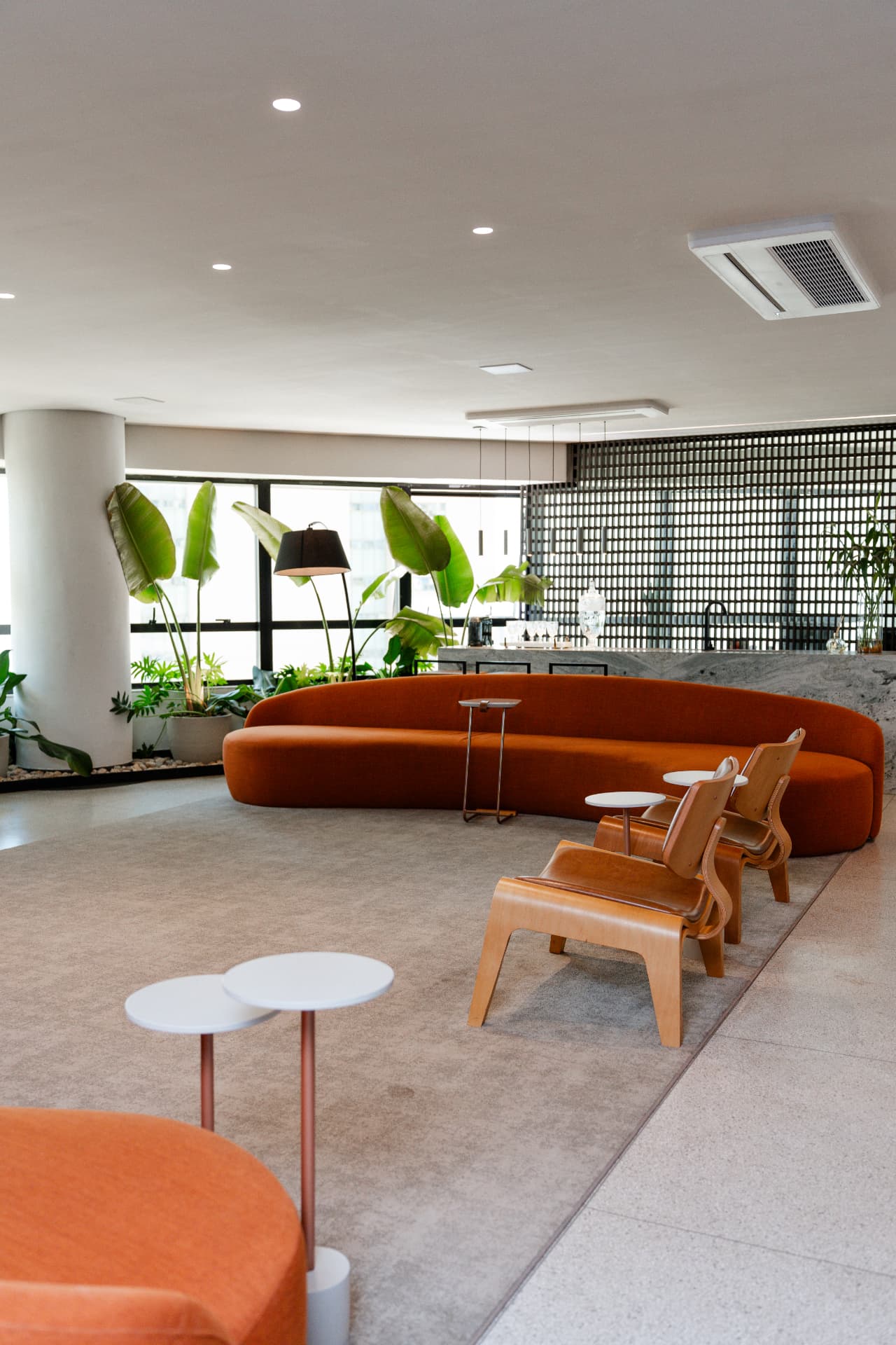 Lounge de espera da Efeito Harmonie, com sofá curvo e jardim interno